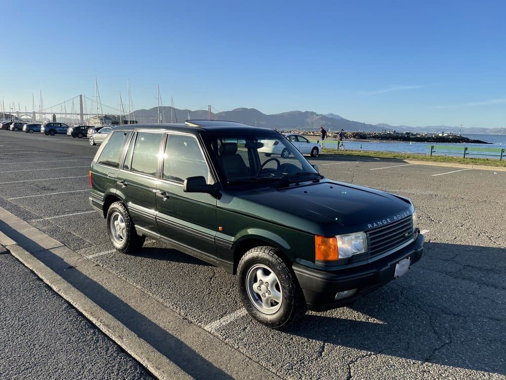 Classic green Range Rover P38 at the San Francisco waterfront with the Golden Gate Bridge in view.